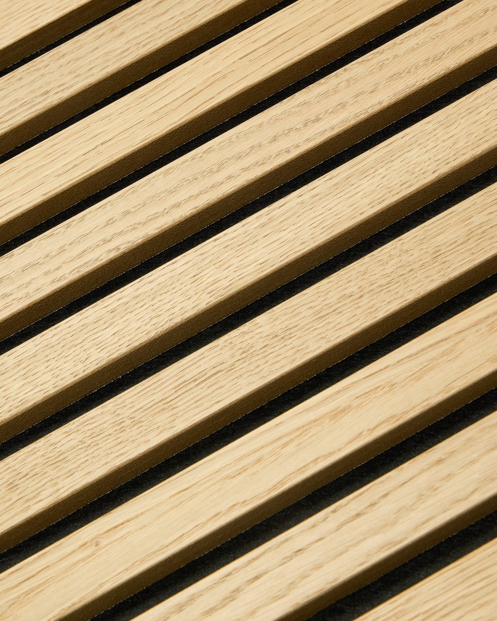 Nahaufnahme von WoodUpp Akupixel Classic Oak Akustikpaneel, 60x60 cm, mit black Filzfugen zwischen Eichenlamellen in einem gestreiften nordischen Design.