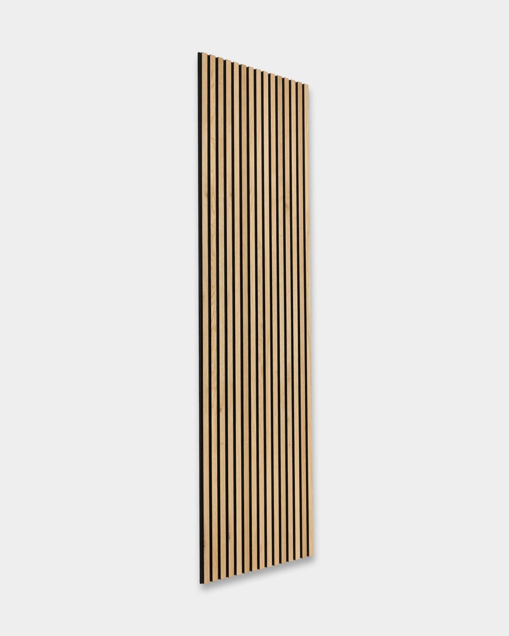 WoodUpp Akupanel in Natural Oak, 240x60 cm: skandinavisches Akustikpaneel mit vertical black Lamellen, montiert an einer weißen Wand. Nordisch-minimalistisches Design.