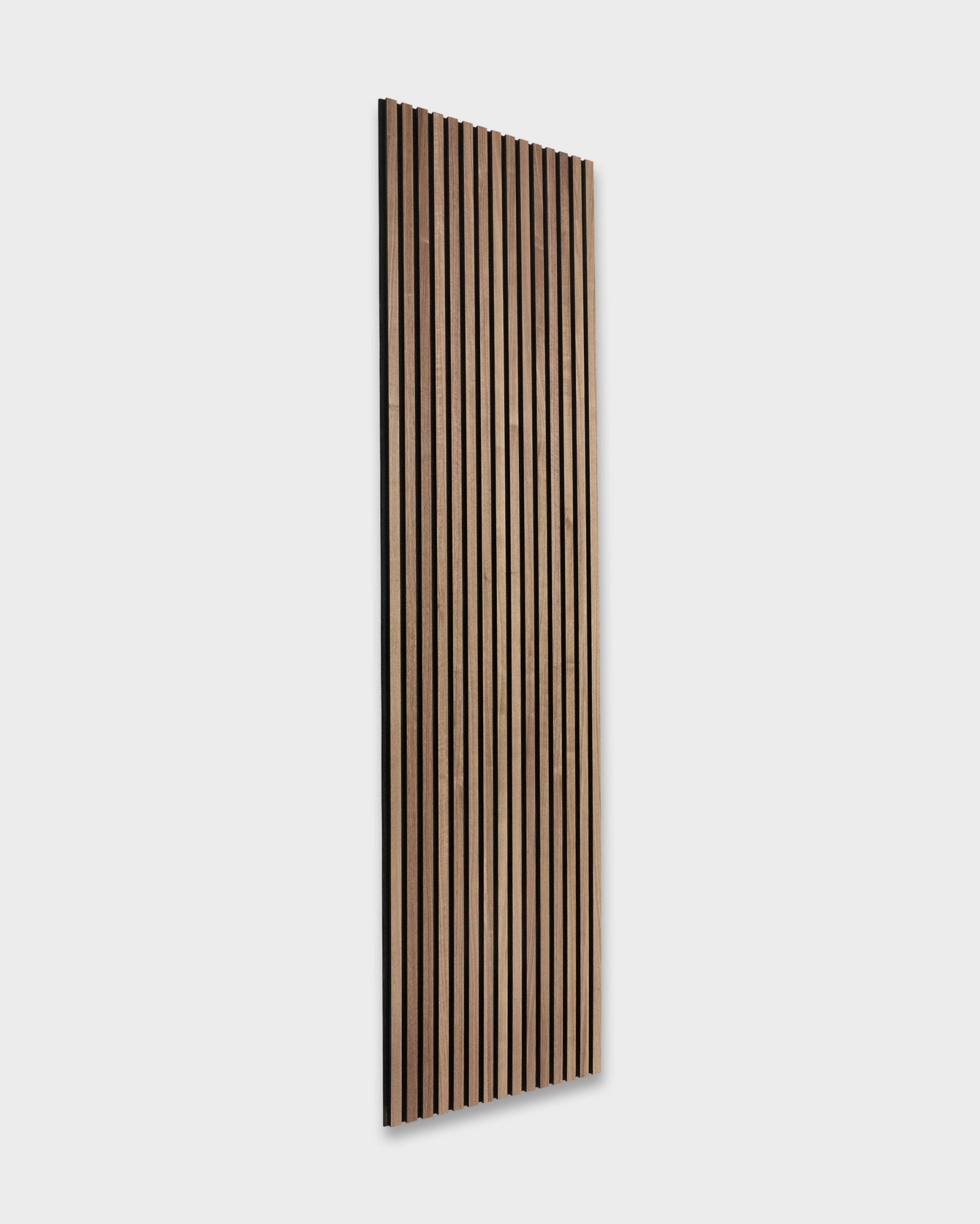WoodUpp Original Akupanel in Walnut (240x60cm) zeigt dunkle brown Akustiklamellen an einer hellen grey Wand und bringt nordisches Design mit skandinavischer Note in den Raum.
