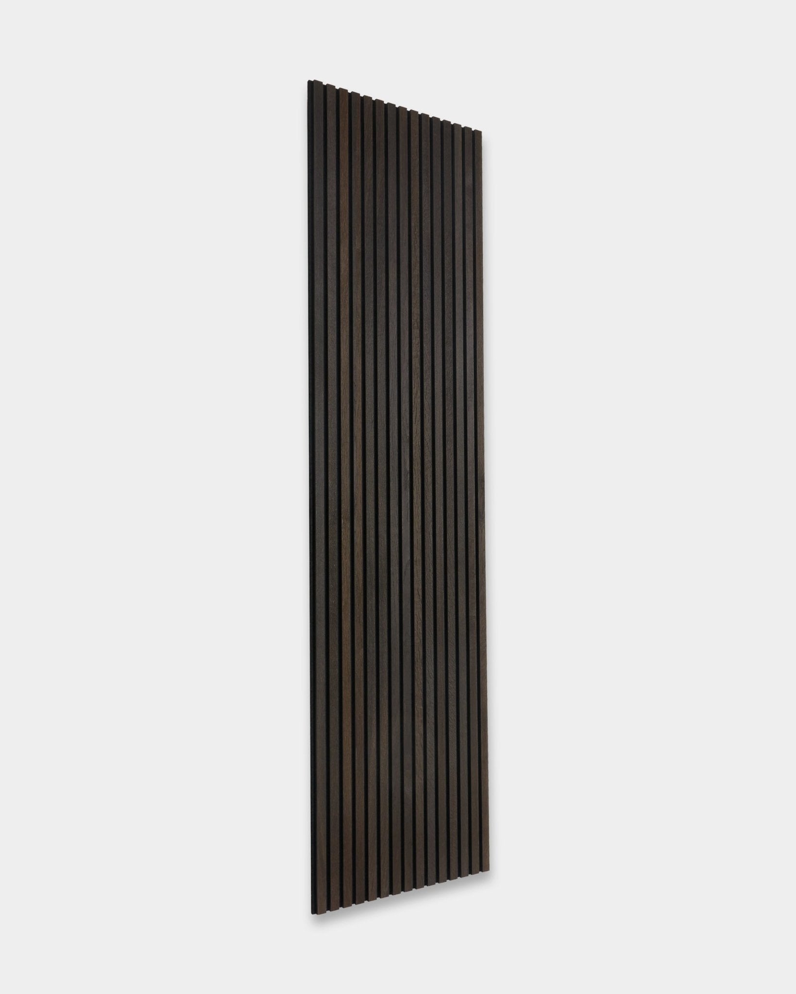Rustic Smoked Oak Akupanel Akustikpaneel von WoodUpp, mit vertical dunklen Holzlamellen, an eine hellgraue Wand gelehnt.