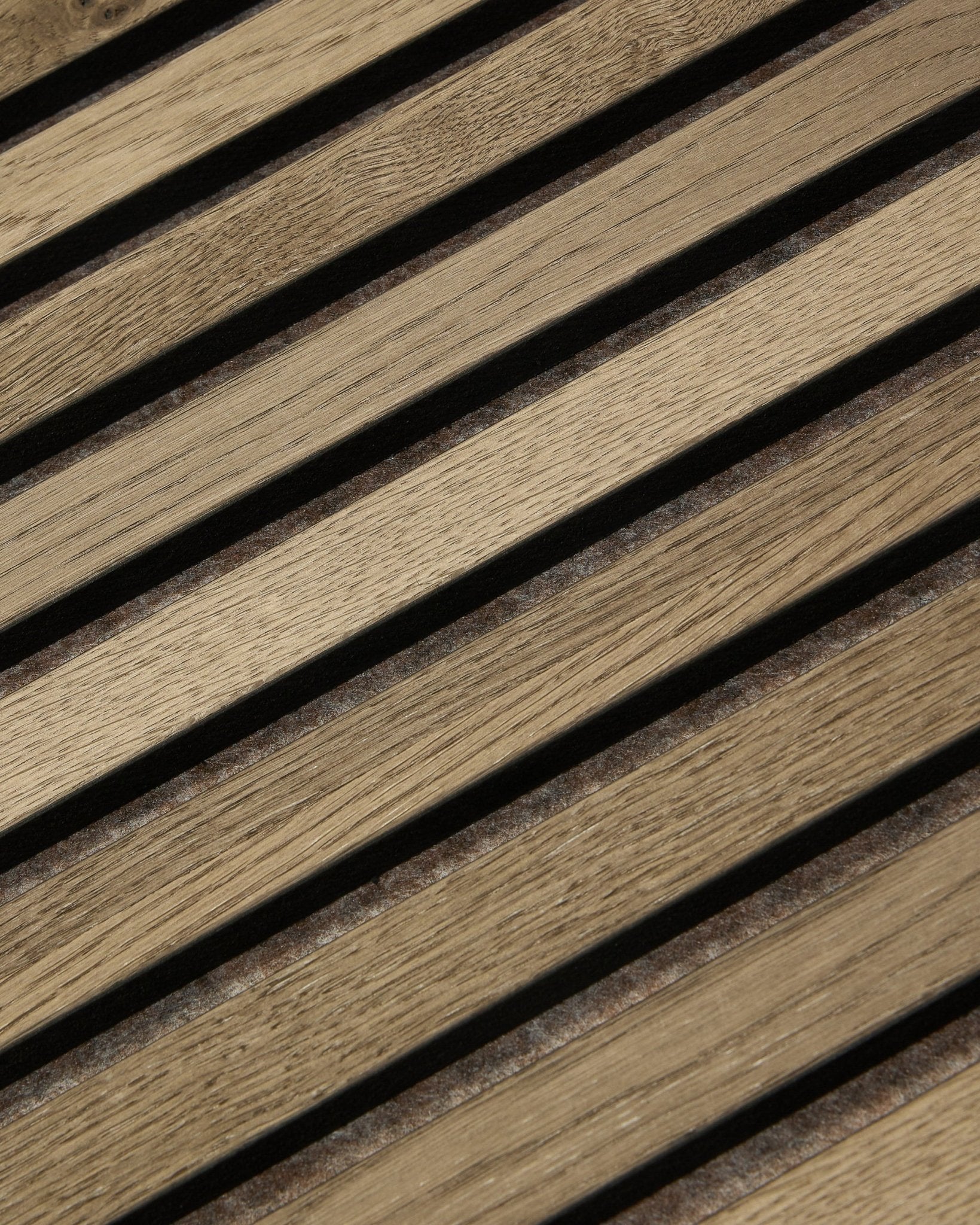 Nahaufnahme von WoodUpp Tonal Akupanel Akustikpaneel in Grey Oak (240x60 cm), die gleichmäßig angeordnete diagonale Lamellen mit natural oak Maserung und nordischem Design zeigt.