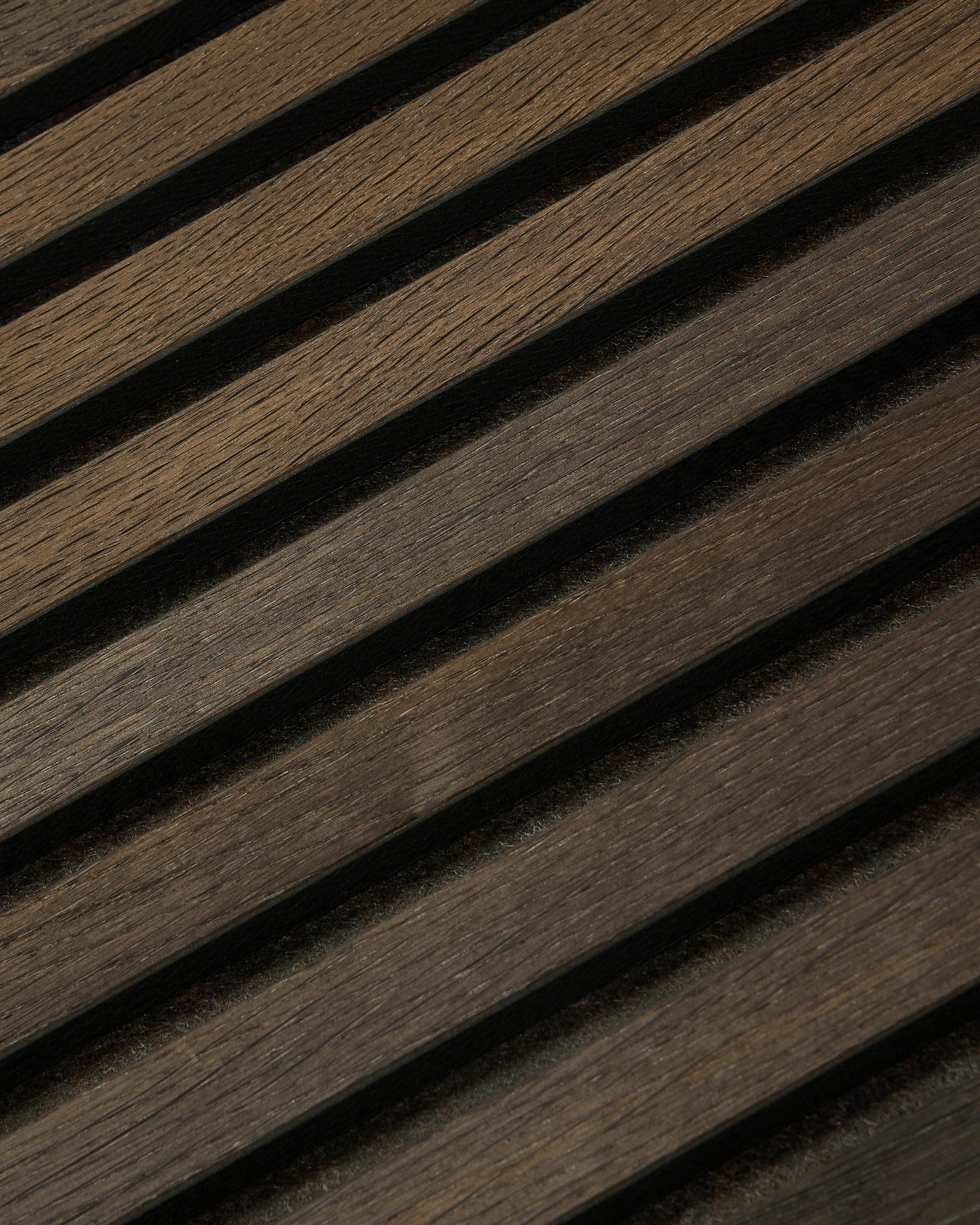 Nahaufnahme von Tonal Akupanel Akustikpaneel in Smoked Oak (240 x 60 cm) von WoodUpp, mit diagonalen, strukturierten nordischen Lamellen im skandinavischen Design.