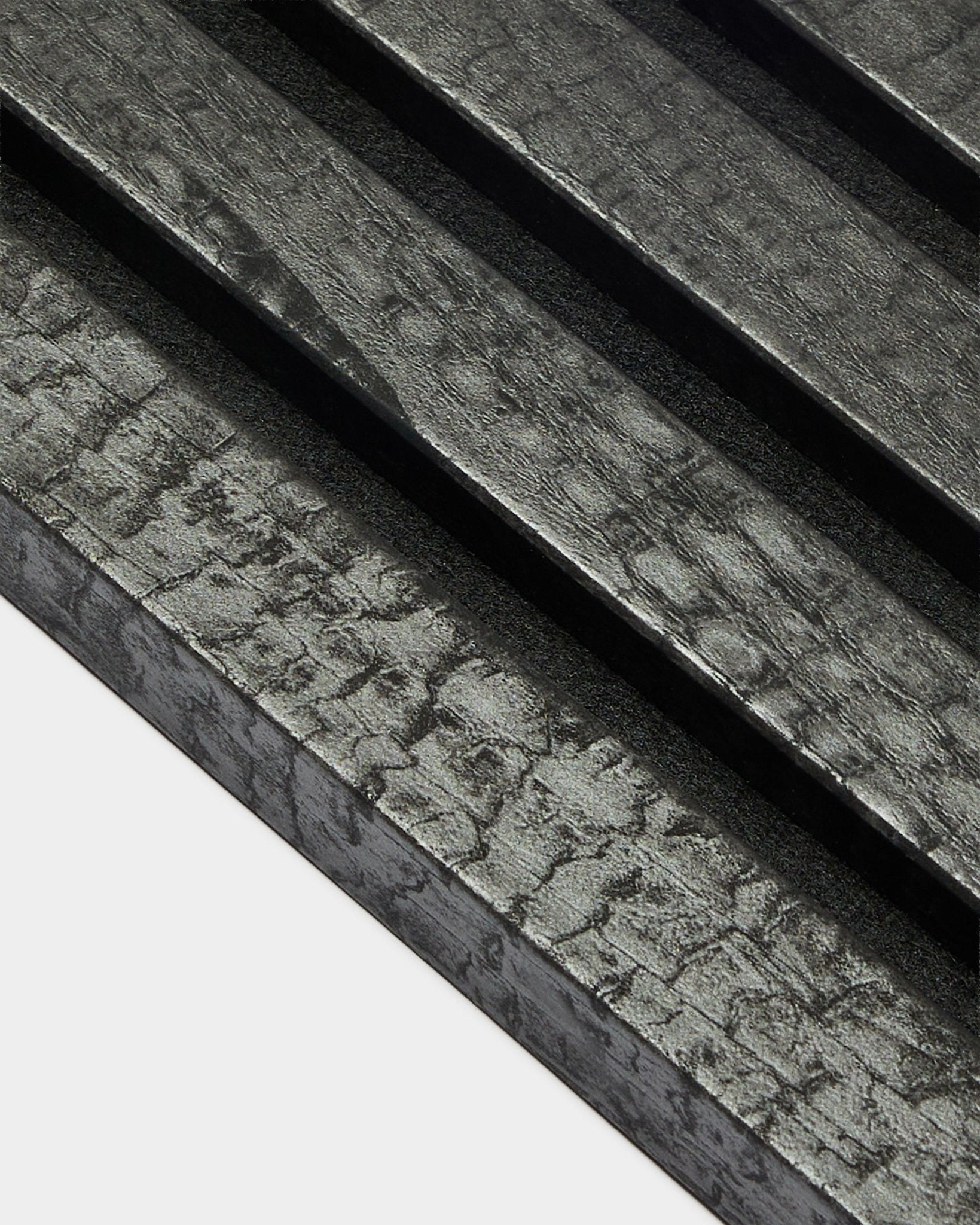 WoodUpp Akupanel End Lamelle in Anthrazit (2,2 cm), mit diagonalen, strukturierten Akustik-Holzpaneelen mit verkohltem black Finish zur Wandmontage.