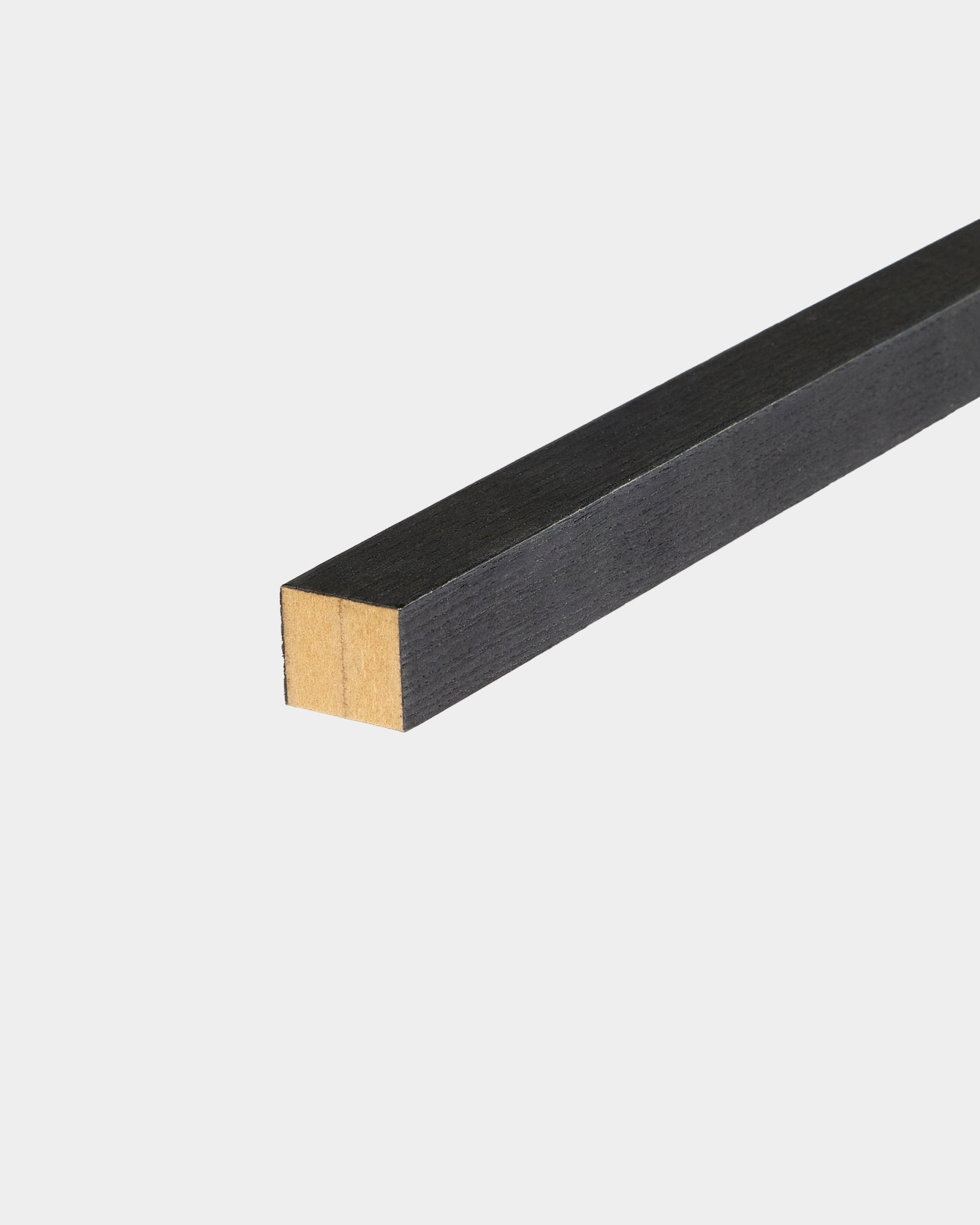 WoodUpp Black Endlamelle in Esche, 2,2 cm, konzipiert für die Akupanel Akustikpaneel-Montage, auf einer weißen Oberfläche liegend, mit einem unbehandelten Ende.