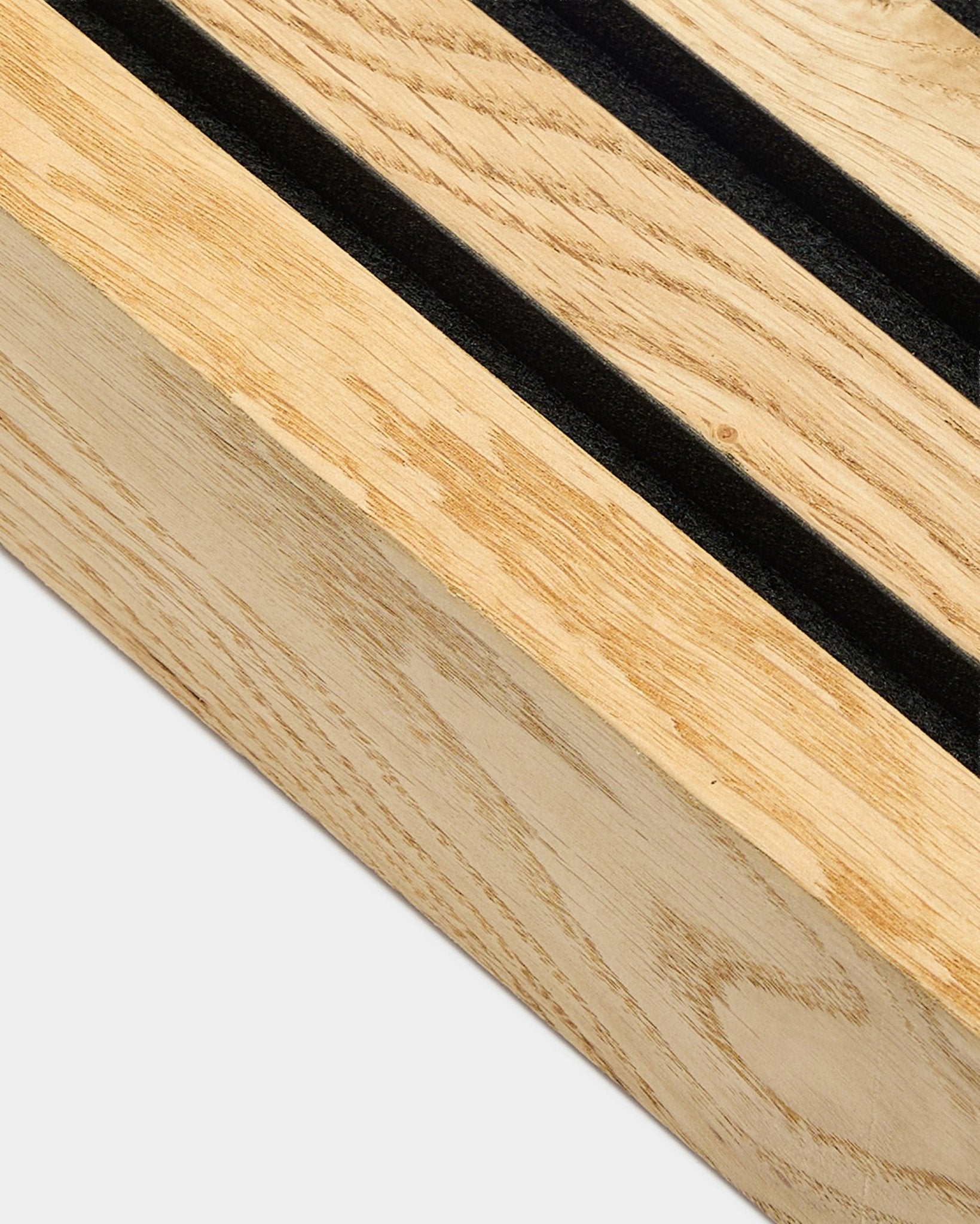 Nahaufnahme einer WoodUpp Akupanel Endlamelle in Rustic Natural Oak, 6,7 cm, mit parallelen black Schlitzen und einem MDF-Rahmen für die akustische Wandmontage.