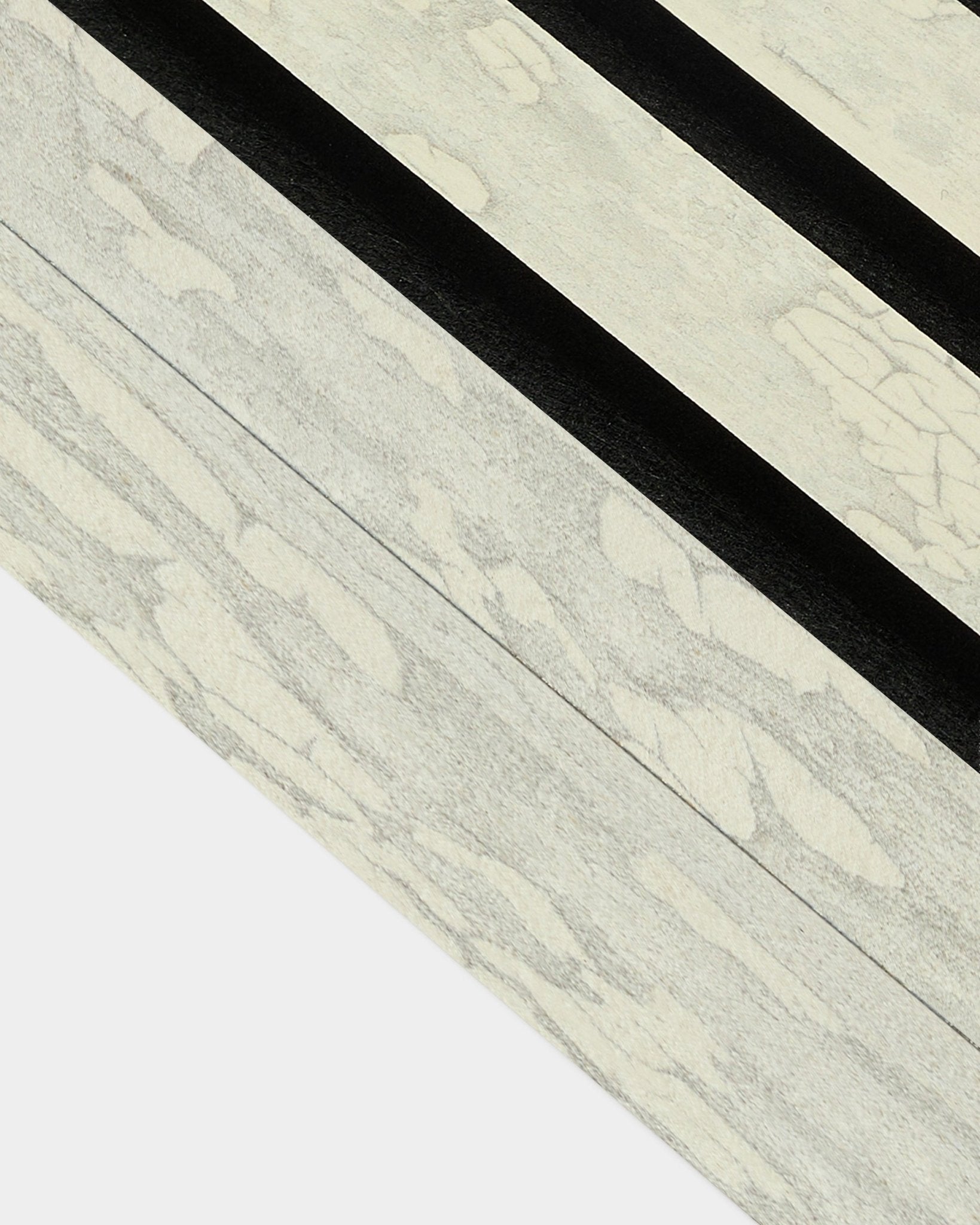 Nahaufnahme der Oxide White Abschlusslamelle (6,7 cm) von WoodUpp für die Installation von Akupanel Akustikpaneel, mit markanten diagonalen black-Mustern im nordischen Design.