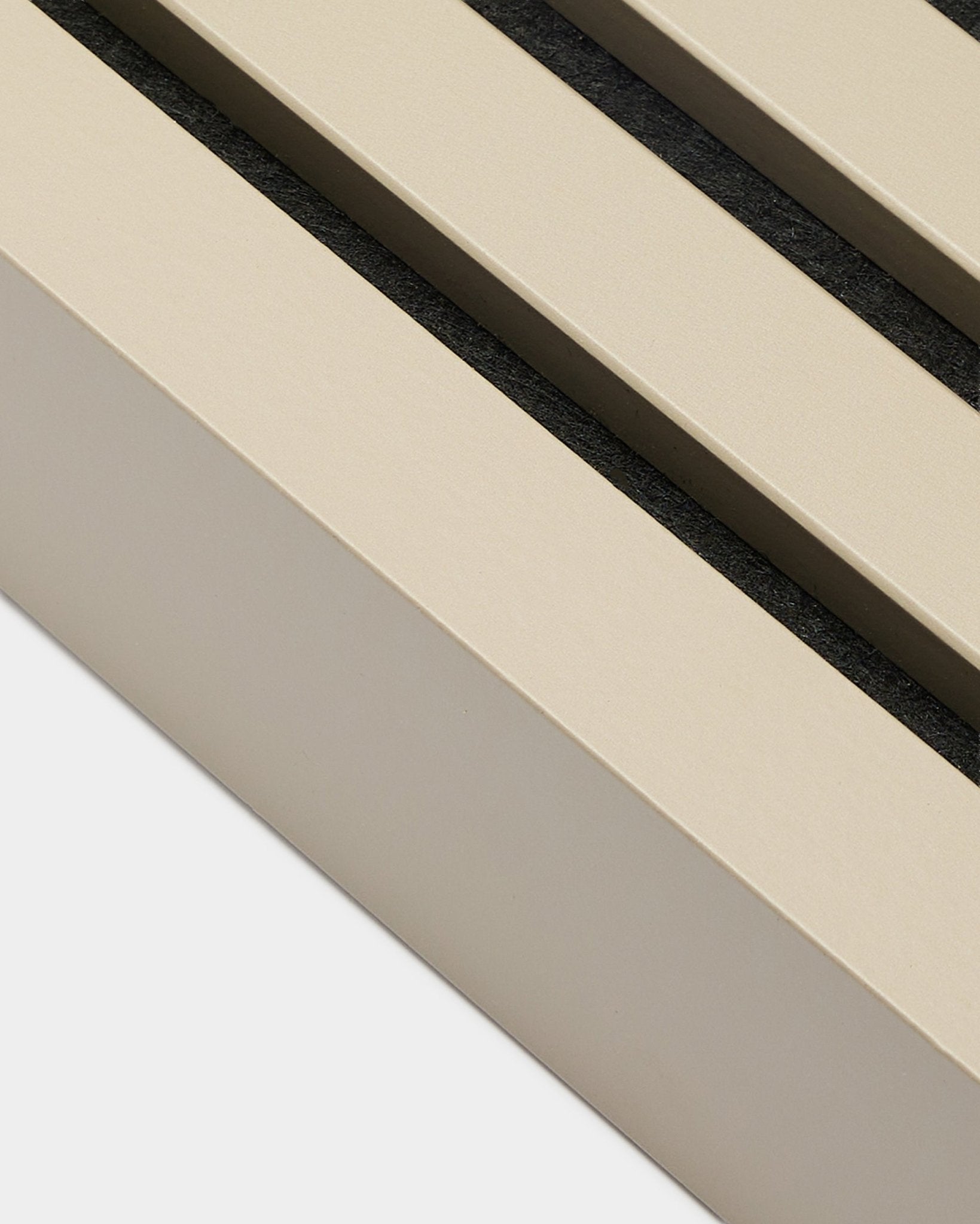 Nahaufnahme der WoodUpp End Lamella in Stone, 6,7 cm breit – Installationszubehör für MDF-Rahmen oder Akupanel Akustikpaneele. Beige Paneellamellen mit black Abständen.