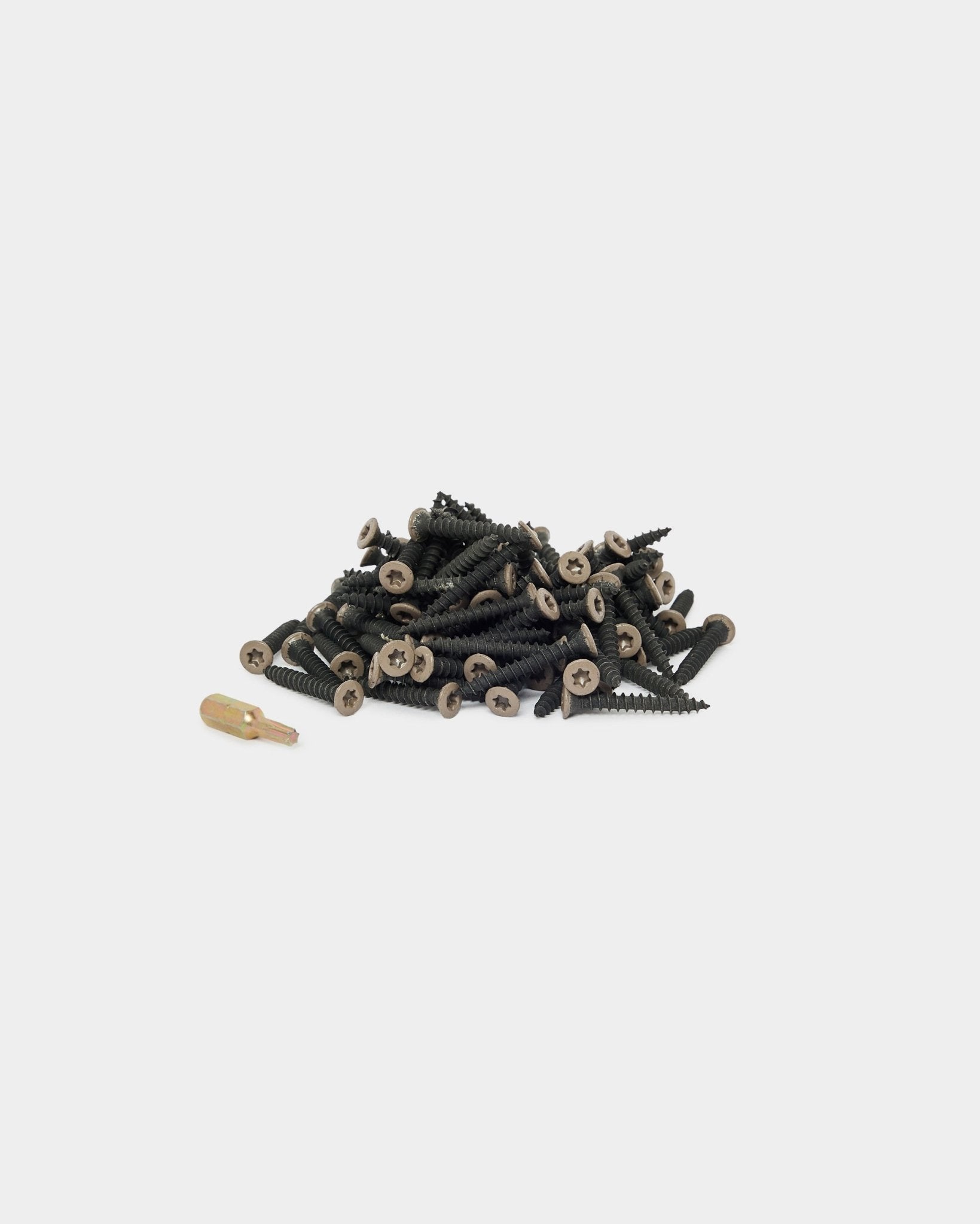 WoodUpp Warm Grey Montageschrauben (100 Stk.) und ein goldener Schrauberbit auf weißem Hintergrund, geeignet für die Montage von Akustikpaneel oder Paneelzubehör.