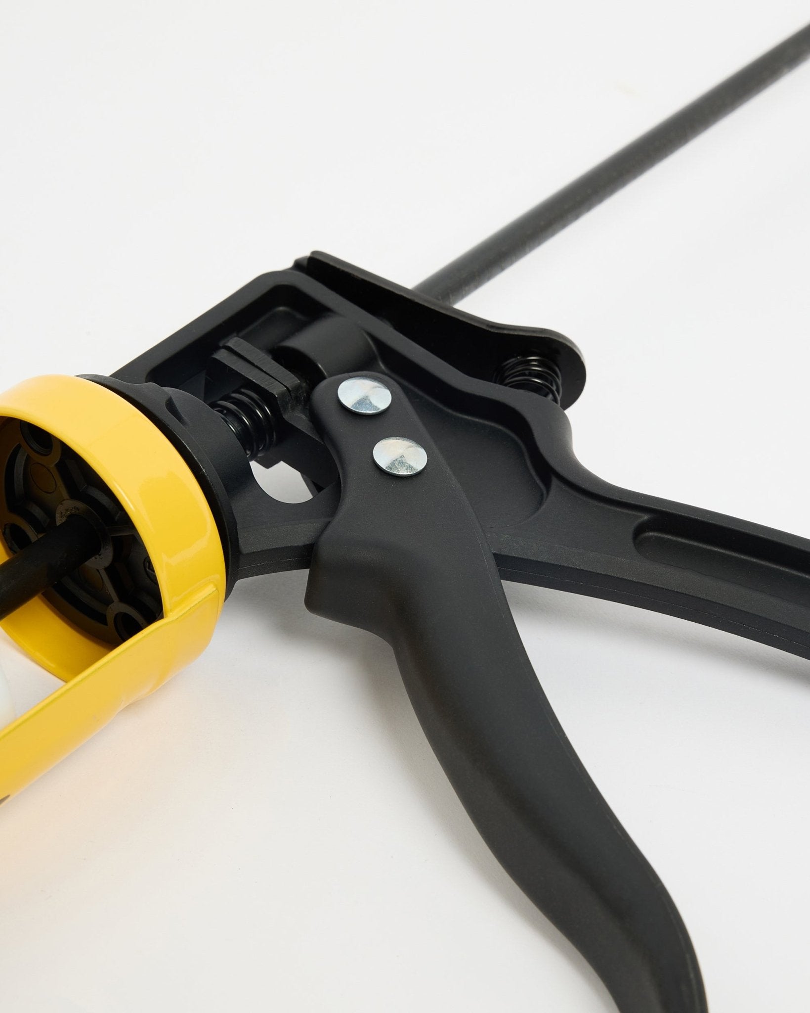 Nahaufnahme der WoodUpp black und gelben Kartuschenpistole (290 ml), ein CREATE Zubehör für die Installation von Akupanel Akustikpaneel, präsentiert auf einer weißen Oberfläche.