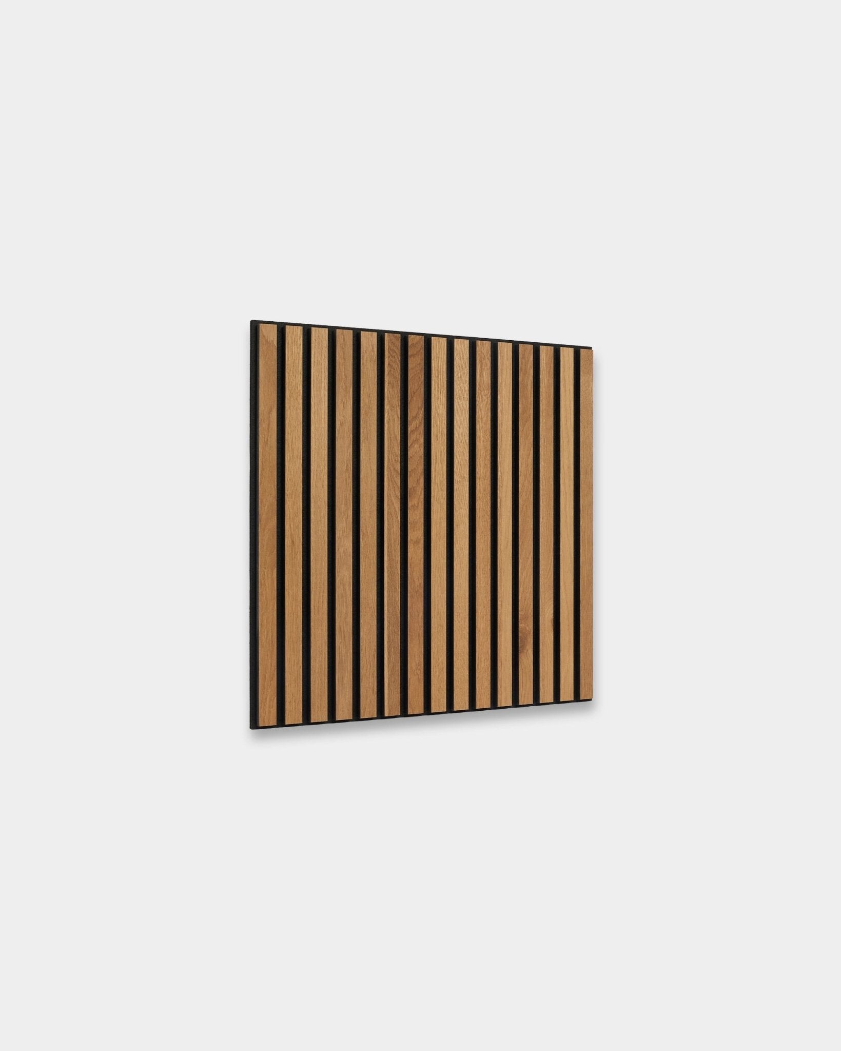 WoodUpp Akupixel Rustic Brown Oak 60x60cm Akustikpaneel mit vertical Lamellen und black Fugen, präsentiert vor einer hellgrauen nordischen Innenwand.