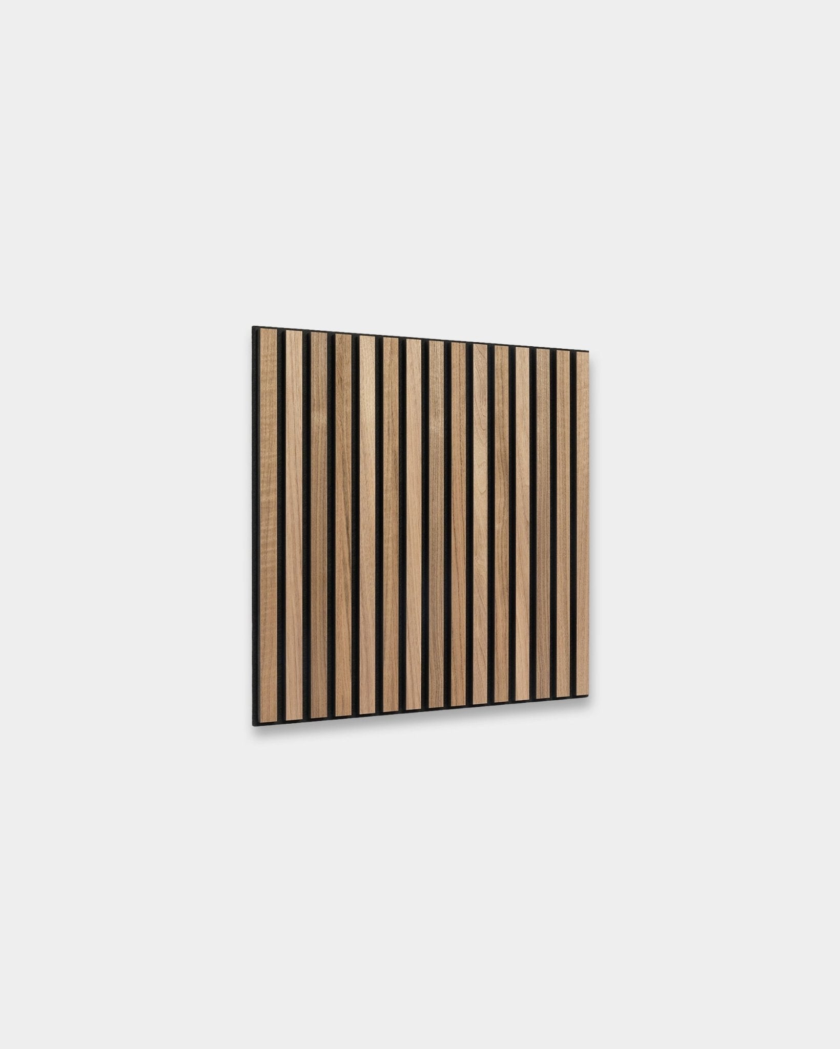 WoodUpp Akupixel Akustikpaneel in Walnuss, 60 x 60 cm, zeigt gleichmäßig angeordnete Walnusslamellen mit black Abständen, montiert an einer hellgrauen Wand im skandinavischen Stil.