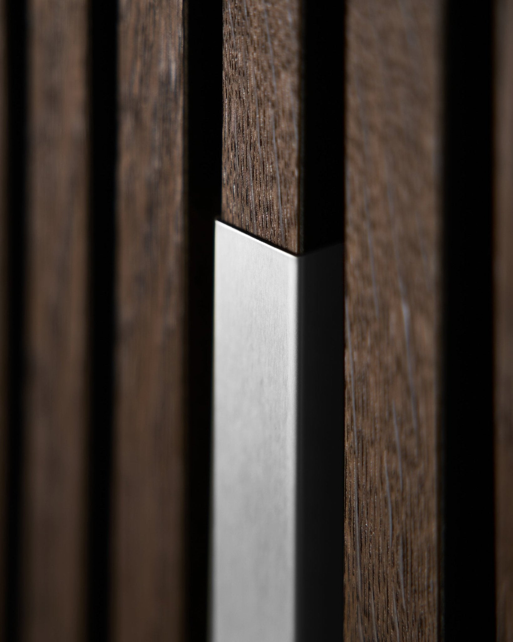 Nahaufnahme von WoodUpp Akupanel Liva | Cover–20 cm in poliertem steel mit vertical Holzlamellen, die die nordische Textur und den Kontrast dieses Akustikpaneel hervorhebt.