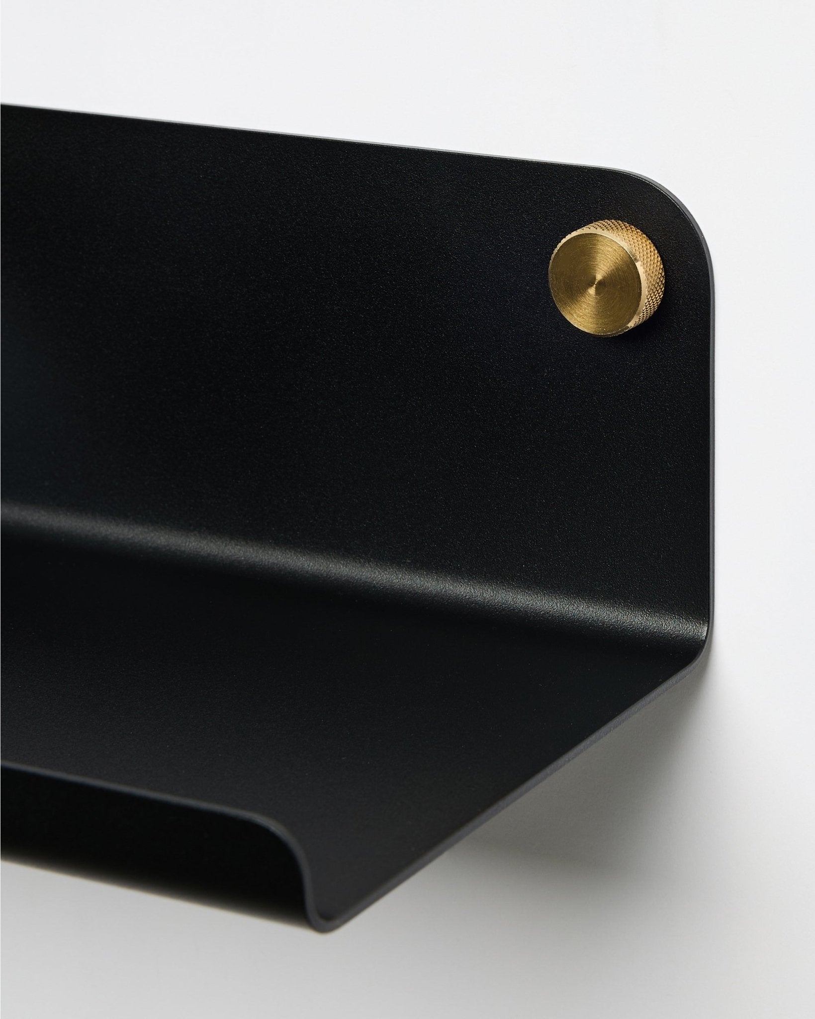 Nahaufnahme des WoodUpp Norr Wide Shelf in black, 35,9 cm, mit gerundeter Kante, mit einer runden brass Schraube an der Wand befestigt. Nordisches minimalistisches Design.