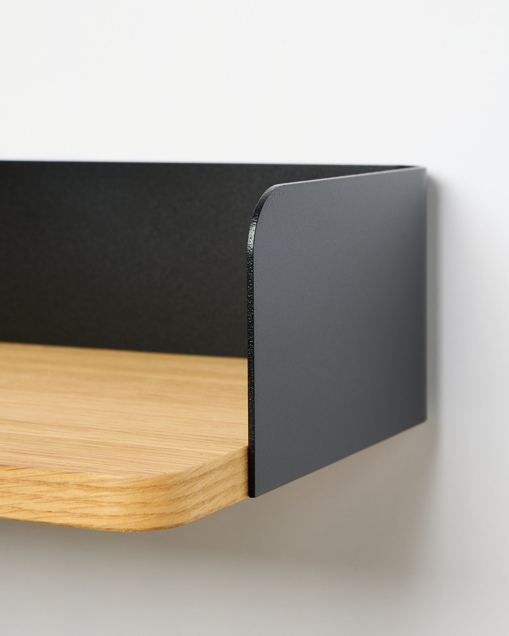 Nahaufnahme des WoodUpp Linn Bücherregals in Natural Oak, 39,9 cm breit, mit einer seitlichen Metallplatte in black; das bohrfreie Regal ist vor weißem Hintergrund zu sehen.