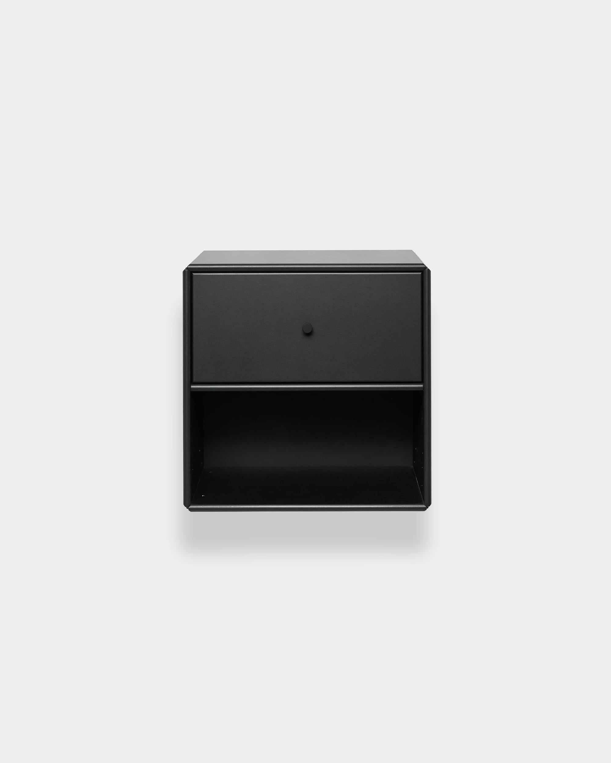 WoodUpp Arka – schwarzes Bücherregal mit einer Schublade und einem offenen Fach, vor hellgrauem Hintergrund. Minimalistisches nordisches Design.