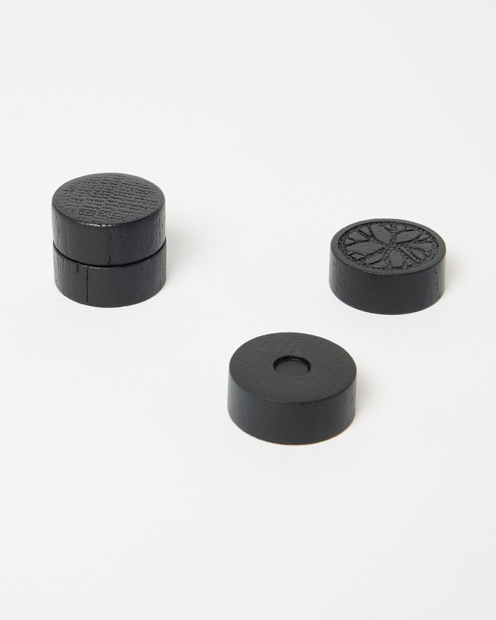 Set aus vier black oak Norr Magneten von WoodUpp, Teil der CREATE Accessoire-Kollektion, ordentlich auf einer sauberen weißen Fläche platziert.