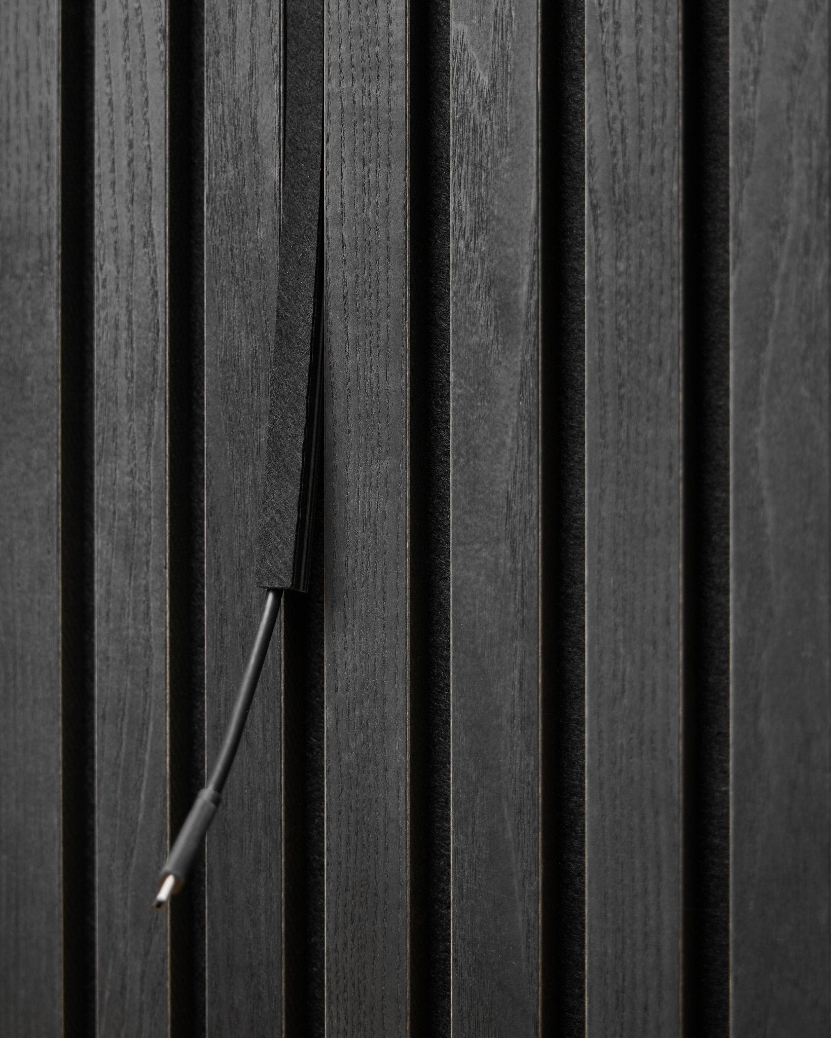 Die Dupps Pop-on Kabelabdeckung (Black, 3 Stk.) von WoodUpp verdeckt Kabel zwischen den Akupanel Akustikpaneel Lamellen und sorgt so für eine aufgeräumte, integrierte Optik.
