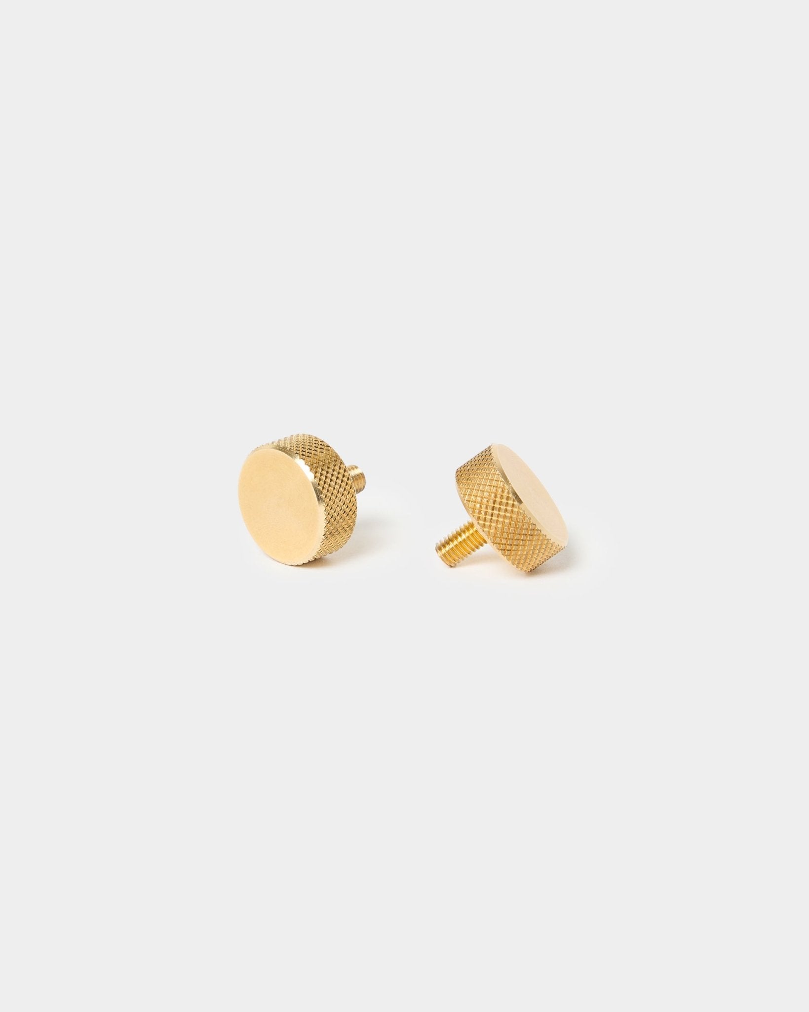 Paar WoodUpp brass Fingerschrauben (M5x10 mm, 20x8.8) mit strukturierten Kanten und kurzem Schaft, entwickelt für Akupanel Zubehör, vor einem schlichten hellen Hintergrund.