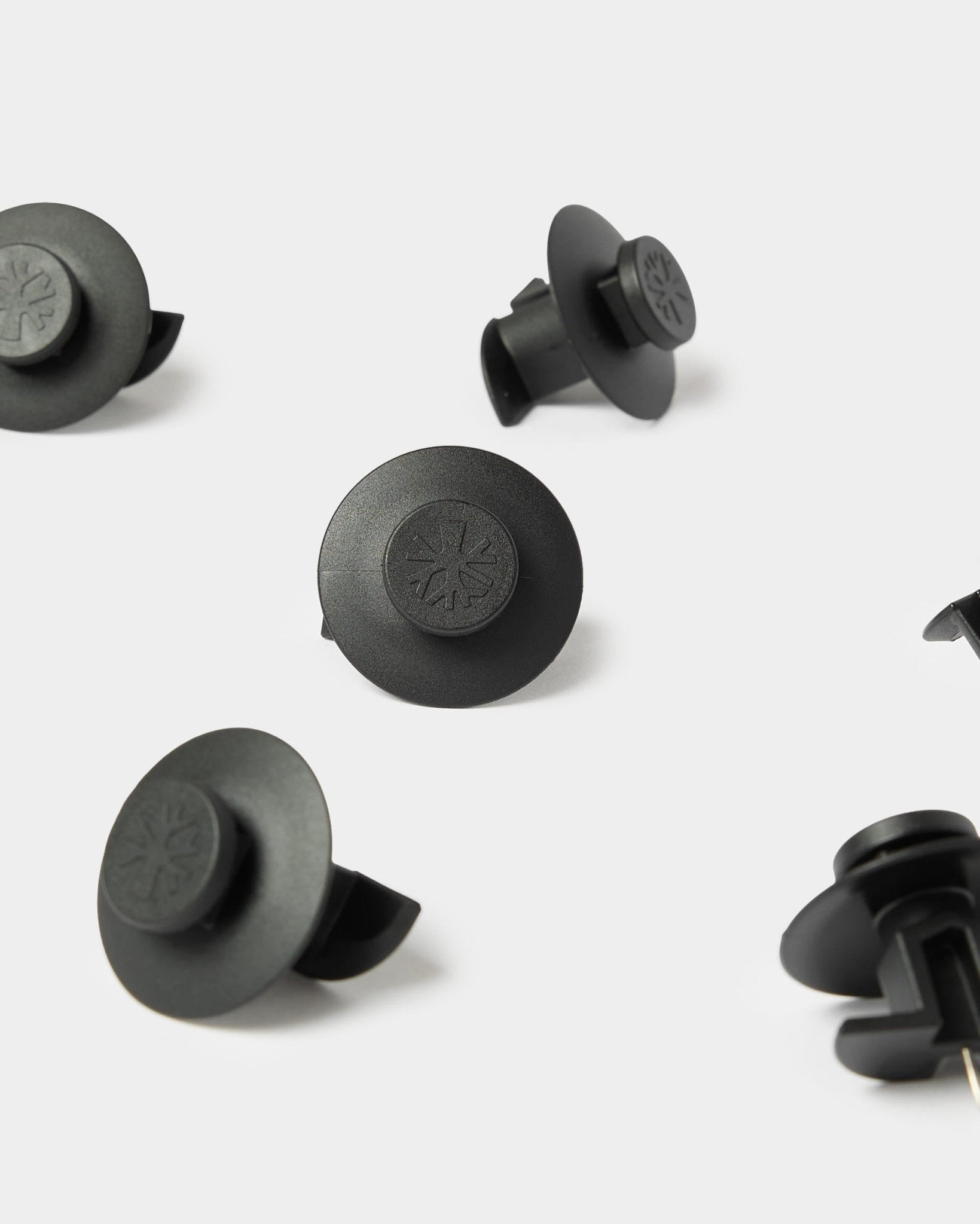 10 schwarze Dupps-Befestigungselemente von WoodUpp, kompatibel mit Akupanel-Akustikplatten für eine sichere Befestigung. Geprägte Symbole auf strapazierfähigem Kunststoff.