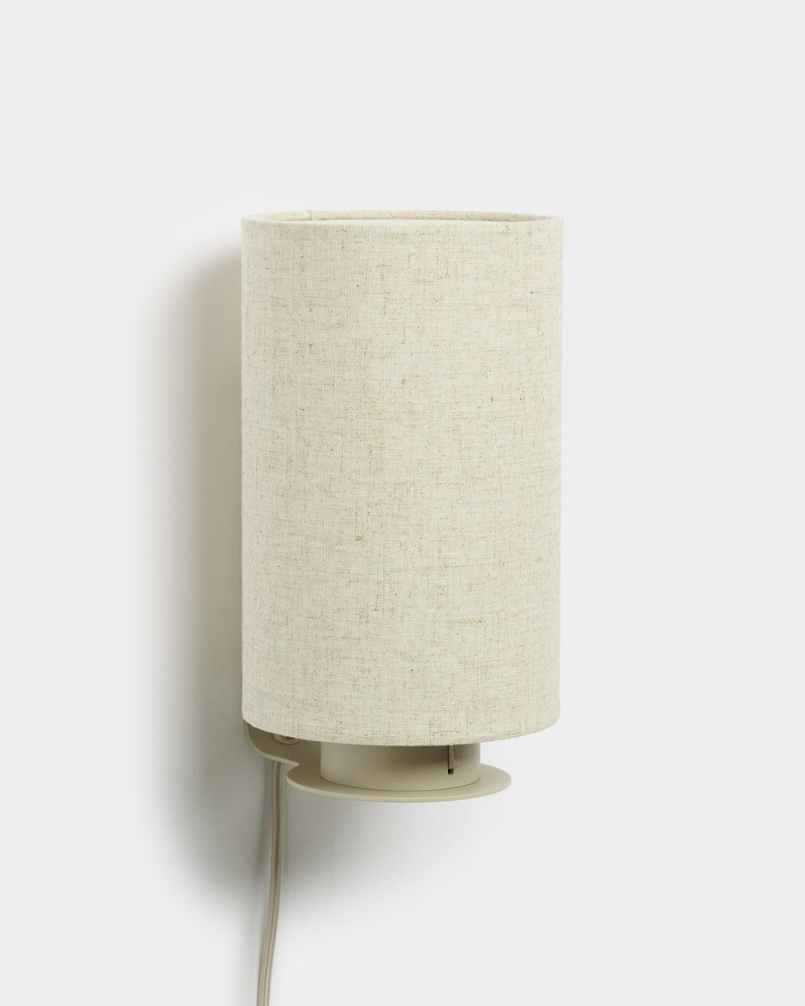 Feya | Wall Lamp von WoodUpp mit einem zylindrischen Schirm aus Leinen-Baumwolle und sichtbarem weißem Kabel, beige Finish, entworfen als Ergänzung zu Akustik-Holzpaneelen.