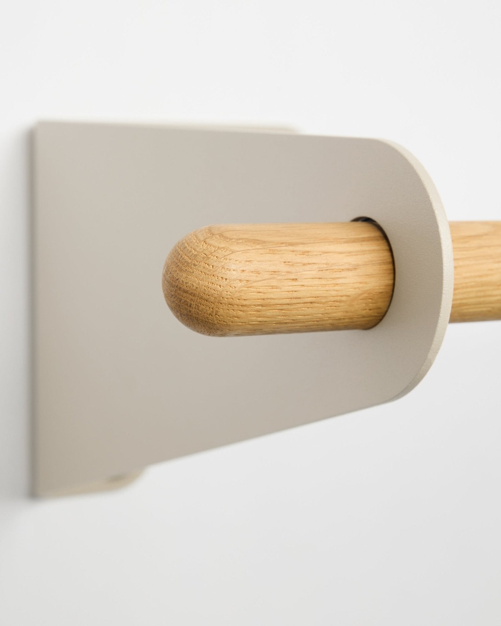 Nahaufnahme der WoodUpp Linn Garderobenstange in beige (75,9 cm), eine massive Eichenstange mit minimalistischer Halterung, an einer weißen Wand montiert, im nordischen Design.