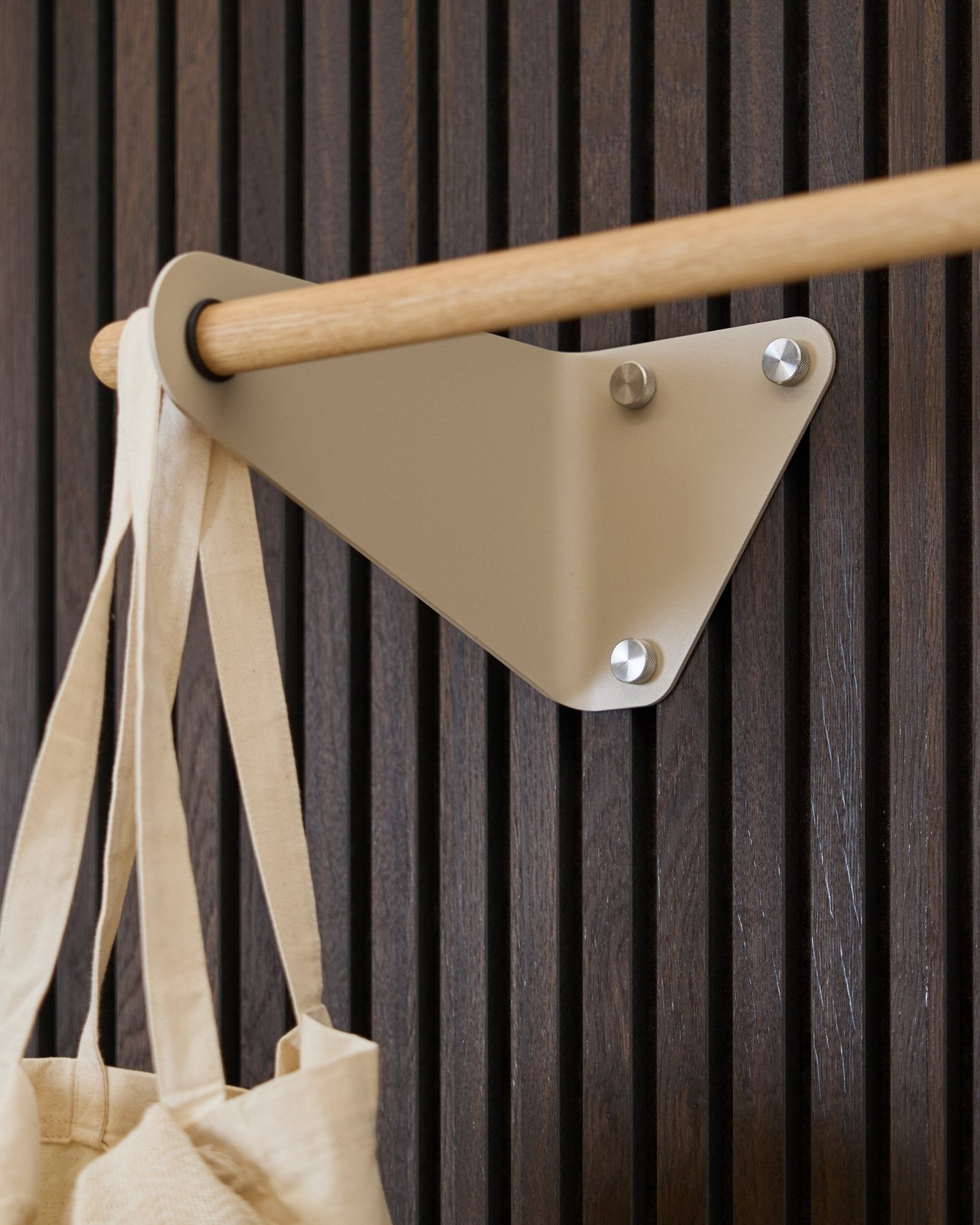 Beige WoodUpp Linn Garderobenstange (115,9 cm), montiert auf Akupanel Akustikpaneel, mit einer cremefarbenen Stofftasche auf der linken Seite.