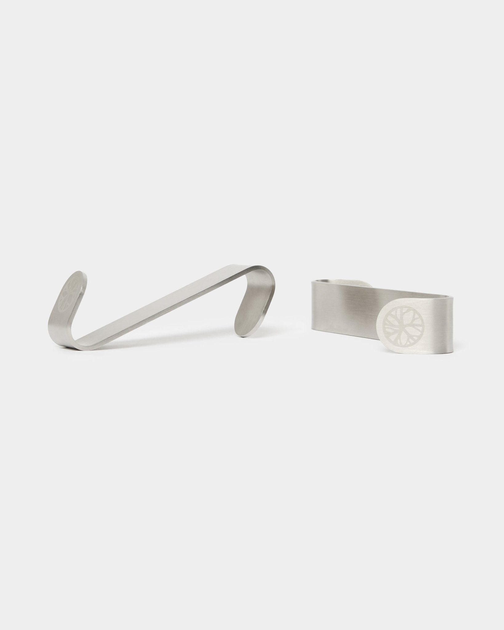 WoodUpp Alva S-Haken BM1 und BM2 Geldklammern, zwei Accessoires aus steel Edelstahl mit graviertem Raddesign, entworfen für nordische Akustik-Holzpaneele.