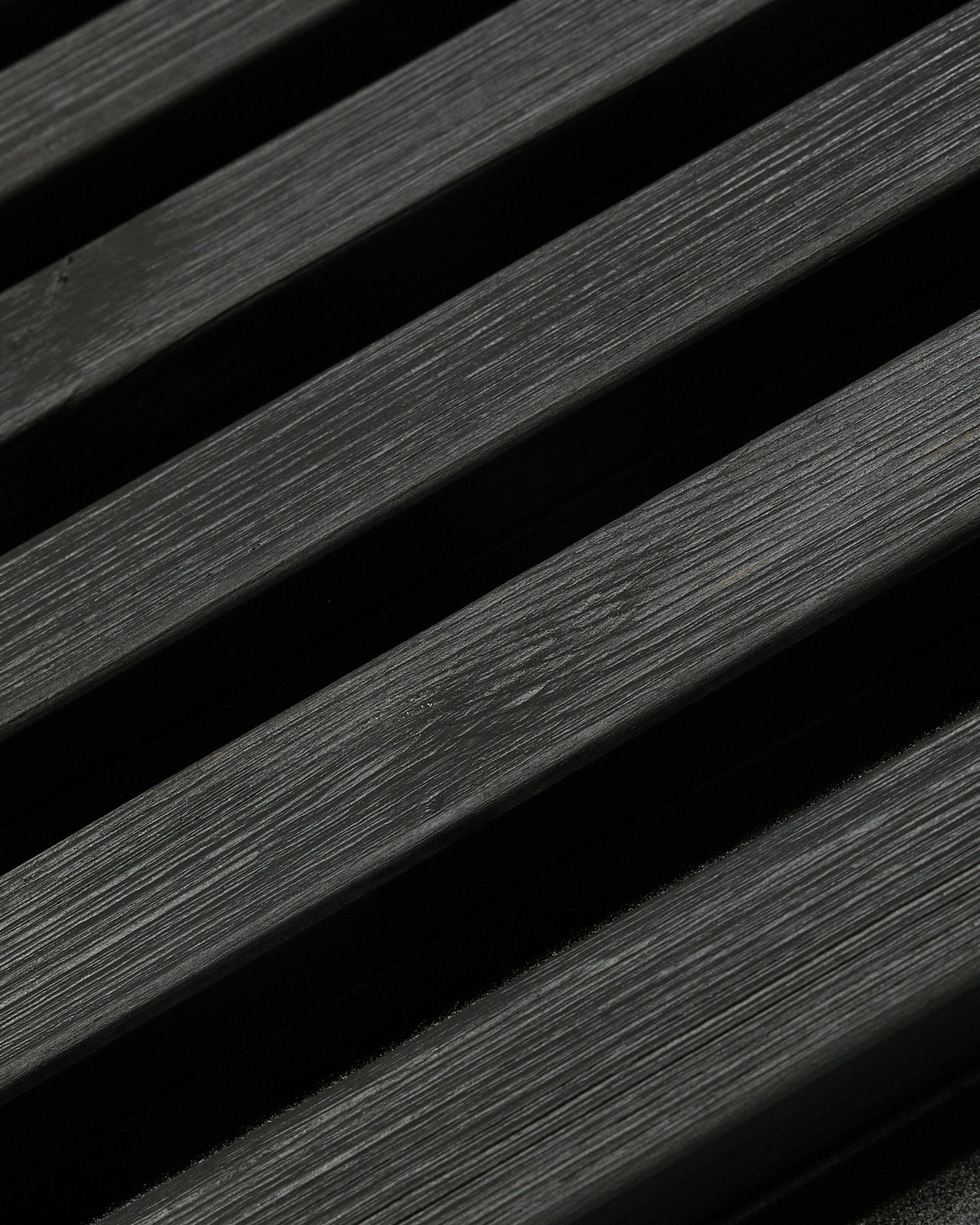 Aluwood Outdoor-Fassadenpaneel von WoodUpp, Thermowood in black Ausführung, 240 x 45,1 cm, mit diagonalen Lamellen aus nordischer Fichte mit sichtbarer Maserung und Schattenwirkung.