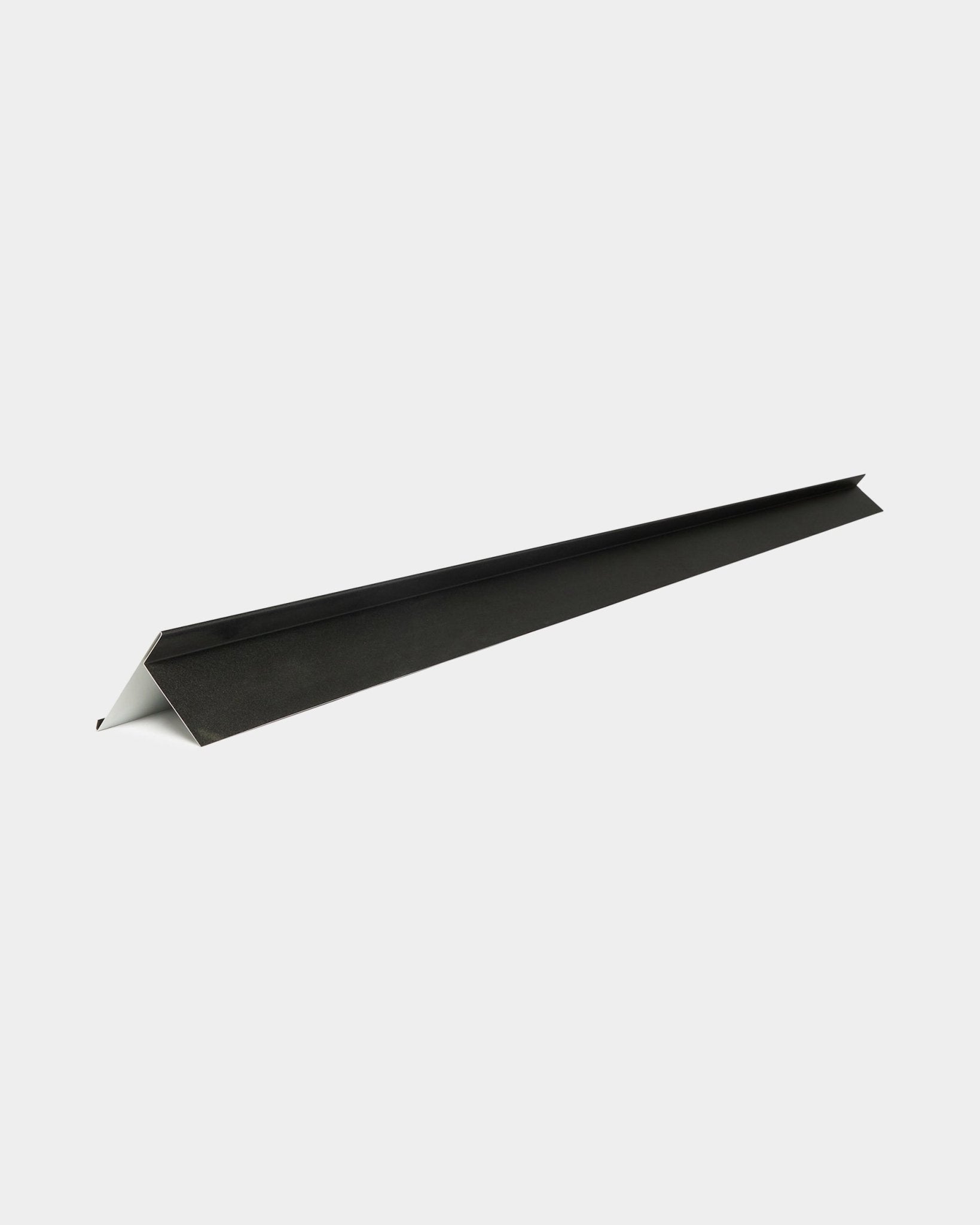 WoodUpp Aluwood Abdeckungs-Kantenprofil, 240 cm, aus black Aluminium mit weißer Unterseite, diagonal auf weißem Hintergrund ausgerichtet. Für Outdoor-Fassadenpaneele.