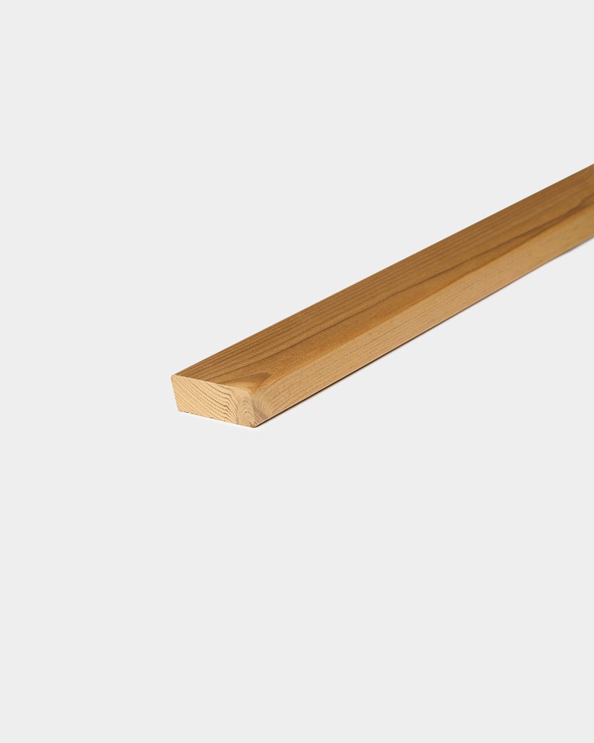 Eine einzelne Aluwood-Fassadenlamelle von WoodUpp mit glatten Kanten liegt auf einem schlichten weißen Hintergrund.