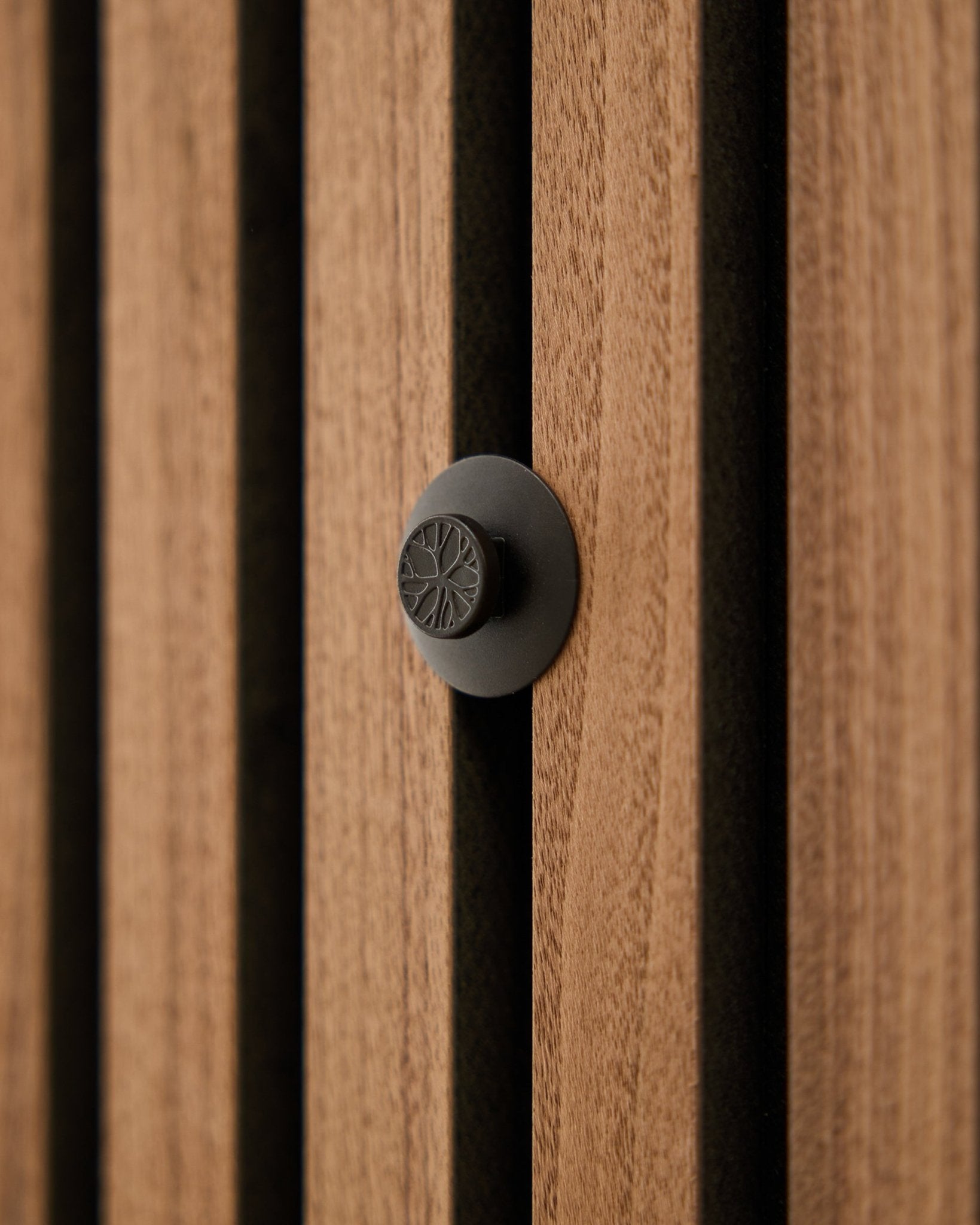 Nahaufnahme eines runden black Knaufs aus dem WoodUpp Dupps Original Set, montiert an einer modernen vertical Akupanel Akustikwand mit Holzlamellen.