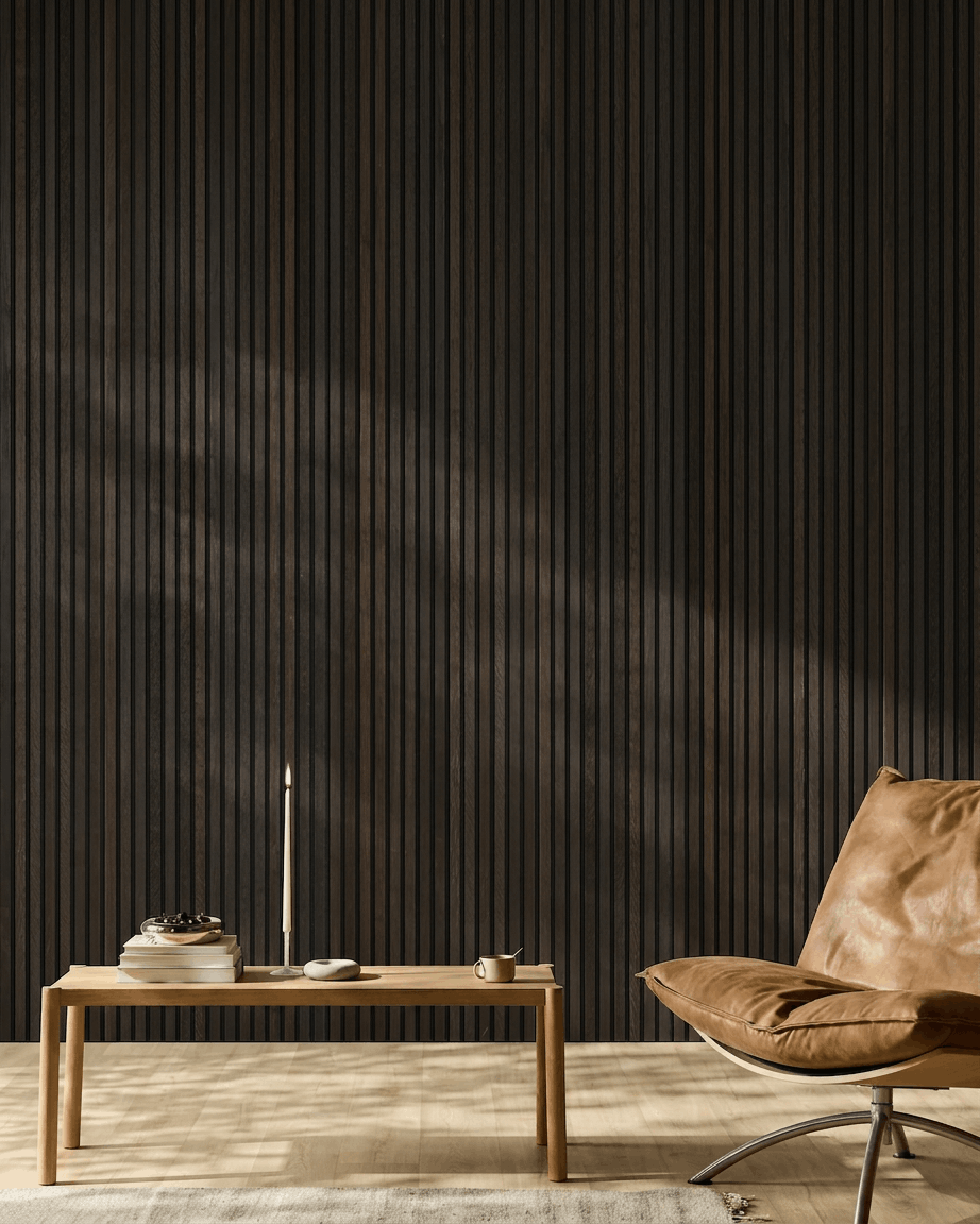Minimalistischer Raum mit einem brown Ledersessel, Couchtisch und Dekor vor einer WoodUpp Akupanel Rustic Smoked Oak Akustik-Holzpaneelwand.